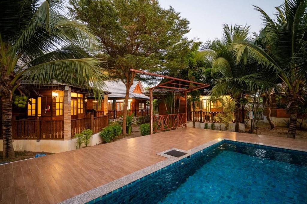 a house with a swimming pool in front of a house at บ้านกูรูรีสอร์ท in Ban Thung Satong
