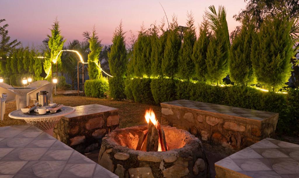 eine Feuerstelle mitten im Garten in der Nacht in der Unterkunft Treebo Samsara Villas And Spa in Rāmnagar