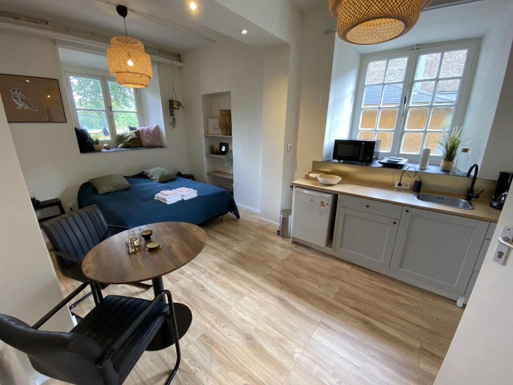 ein Schlafzimmer mit Bett und Tisch und eine Küche in der Unterkunft Modern Studio 3 in Historic Abbey in Bemelen