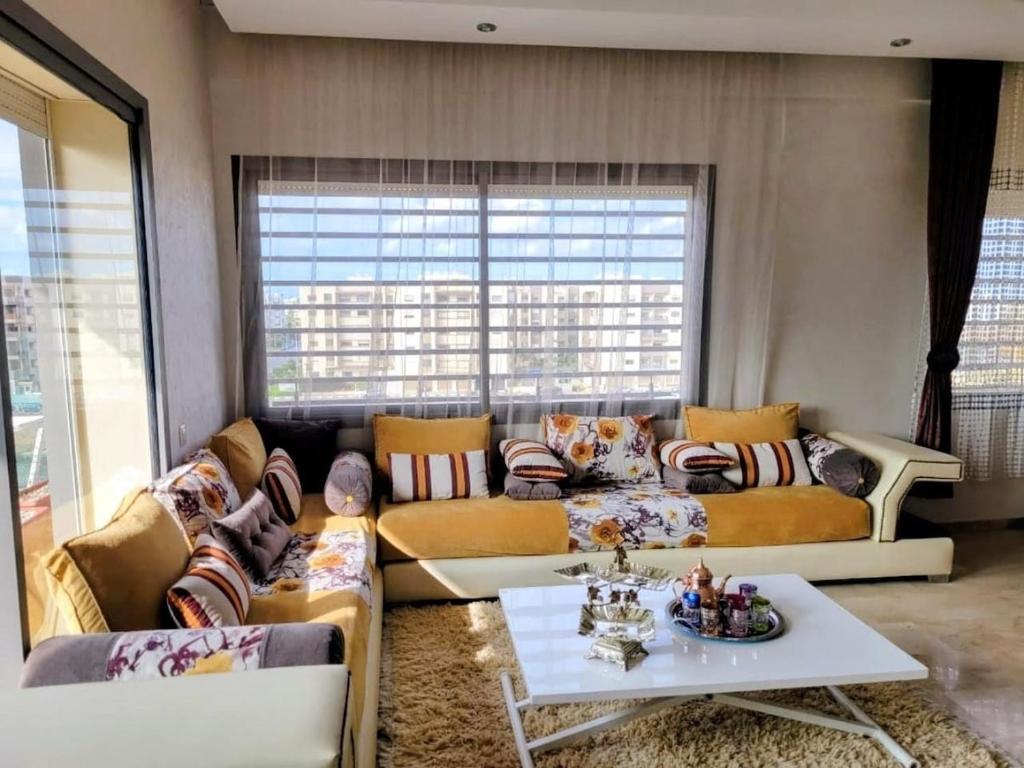 a living room with two couches and a table at 3BR Near Airport Secure,Equipped stay and transit in Nouaseur