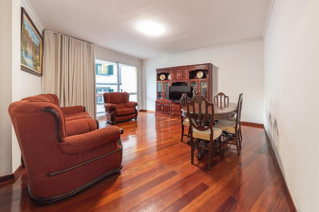 un soggiorno con un tavolo e una sala da pranzo di Esmael Apartment By Mth a Funchal
