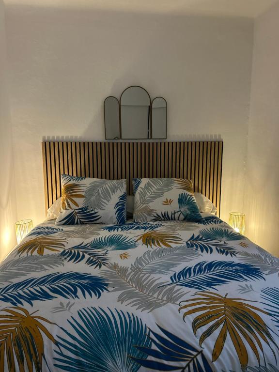 Appartement charmant au cœur de Saint-Rémy, idéal pour une escapade provençale ! في سان ريمي دو بروفنس: غرفة نوم بها سرير مع لحاف أزرق وأبيض