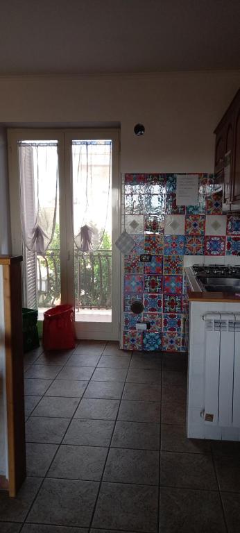 a kitchen with a view of a room with a door at A Santy's House 1piano-no lift-raggiungibile a piedi aeroporto-fermata bus fiera di roma a 3 minuti-NO ANIMALI bed FOR A FEE A PAGAMENTO in Fiumicino