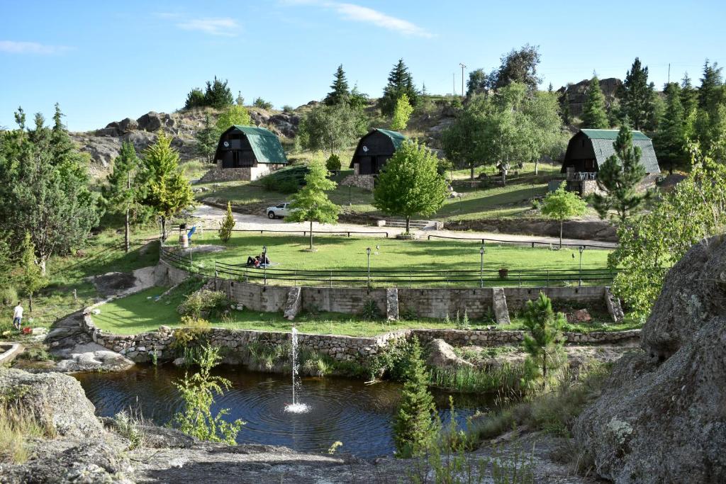 a view of a farm with a pond and buildings at Village in La Cumbrecita