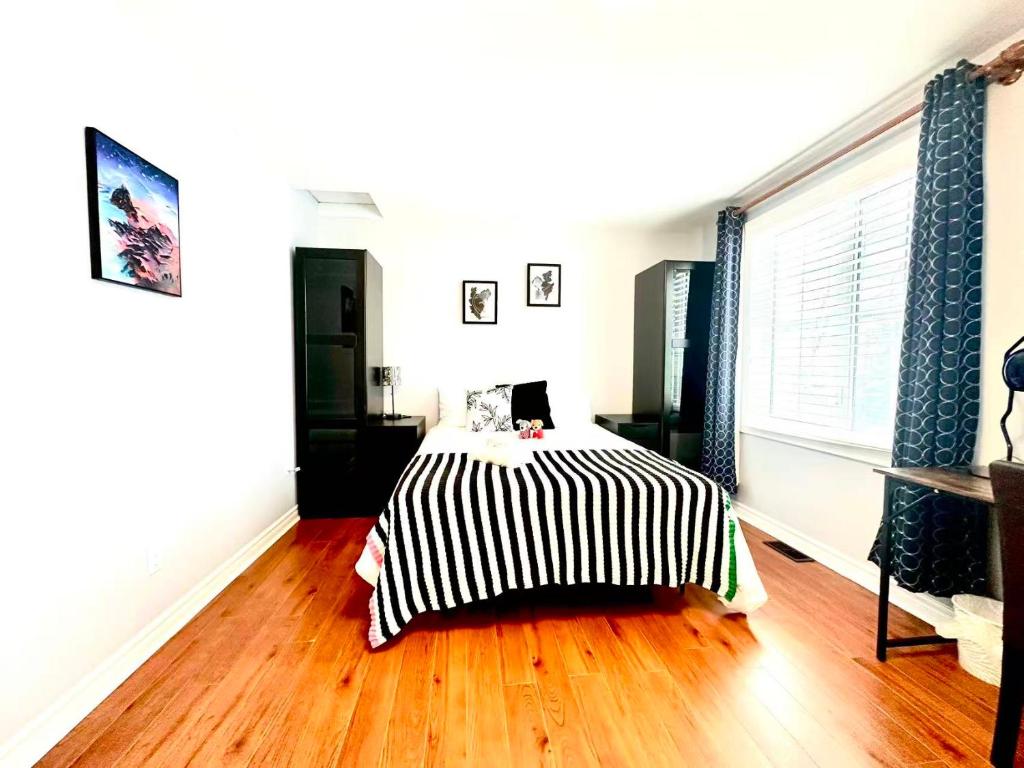 um quarto com uma cama com um cobertor preto e branco em Cozy Queen room with Shared Bath near Seneca Finch 404 em Toronto