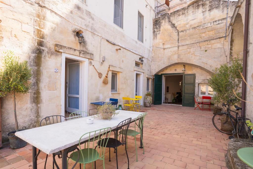 een patio met een witte tafel en stoelen bij Corte Oliveta in Matera