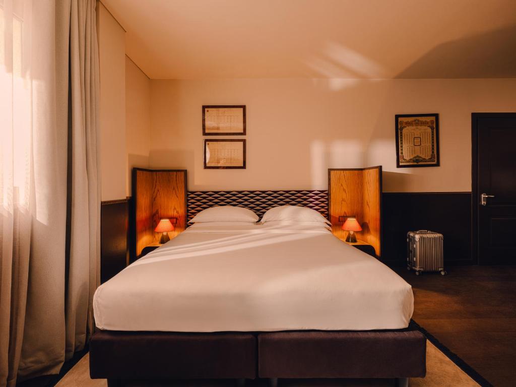 1 cama blanca grande en una habitación con 2 lámparas en Aethos Milan, en Milán