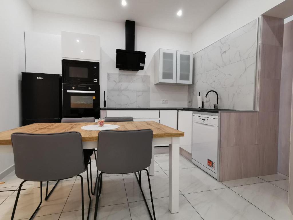 イーペルにあるVakantiehuis HA1の木製のテーブルと椅子のあるキッチン