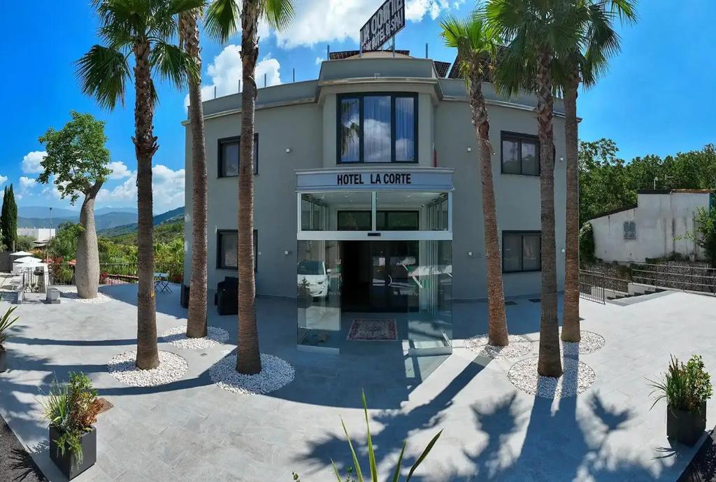 een gebouw met palmbomen ervoor bij La Corte Park Hotel & Spa in Palma Campania