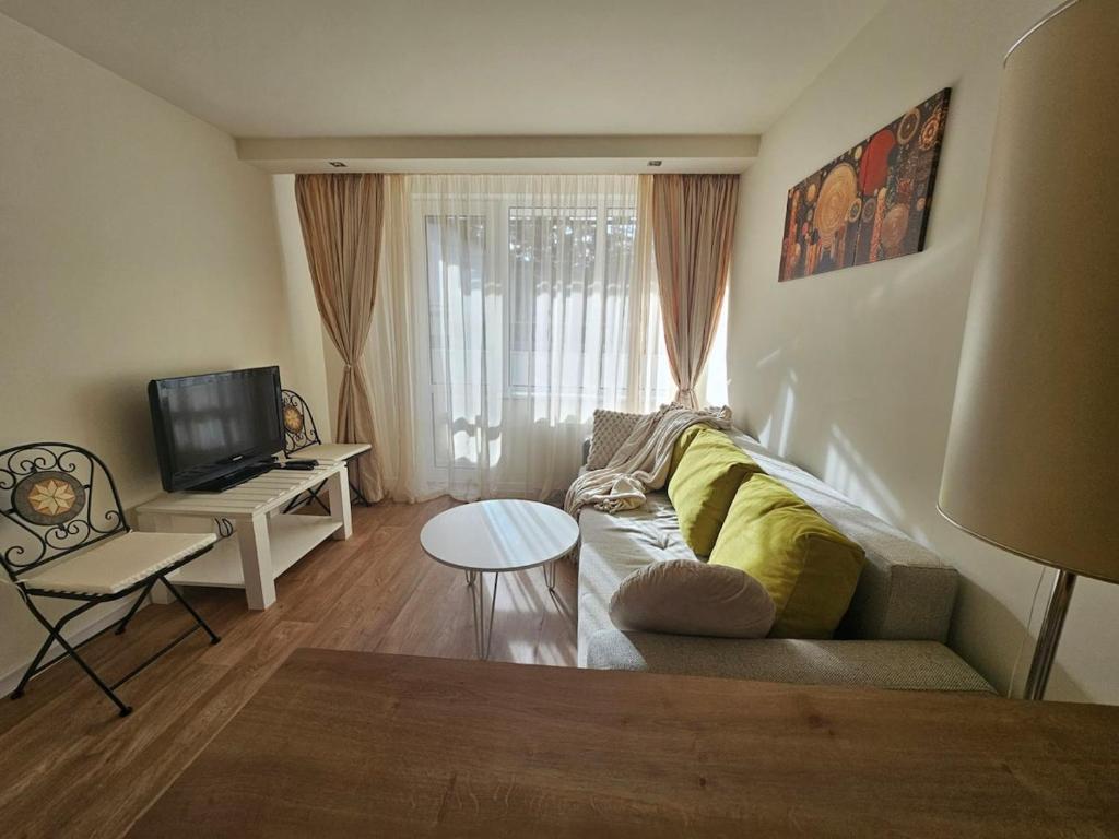 un soggiorno con un divano e una TV di Sunlit Forest Suite a Borovets