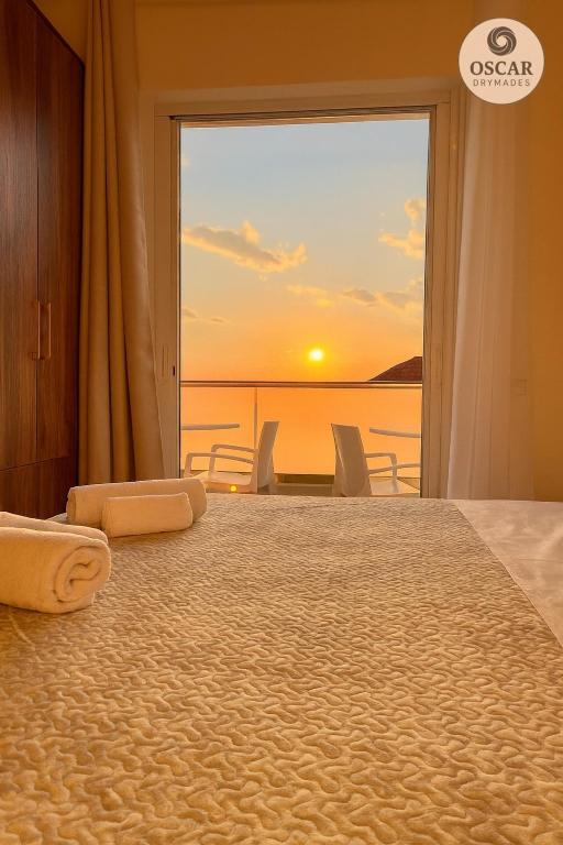 a bedroom with a bed with a view of the ocean at Oscar’s Apartments Drymades in Dhërmi