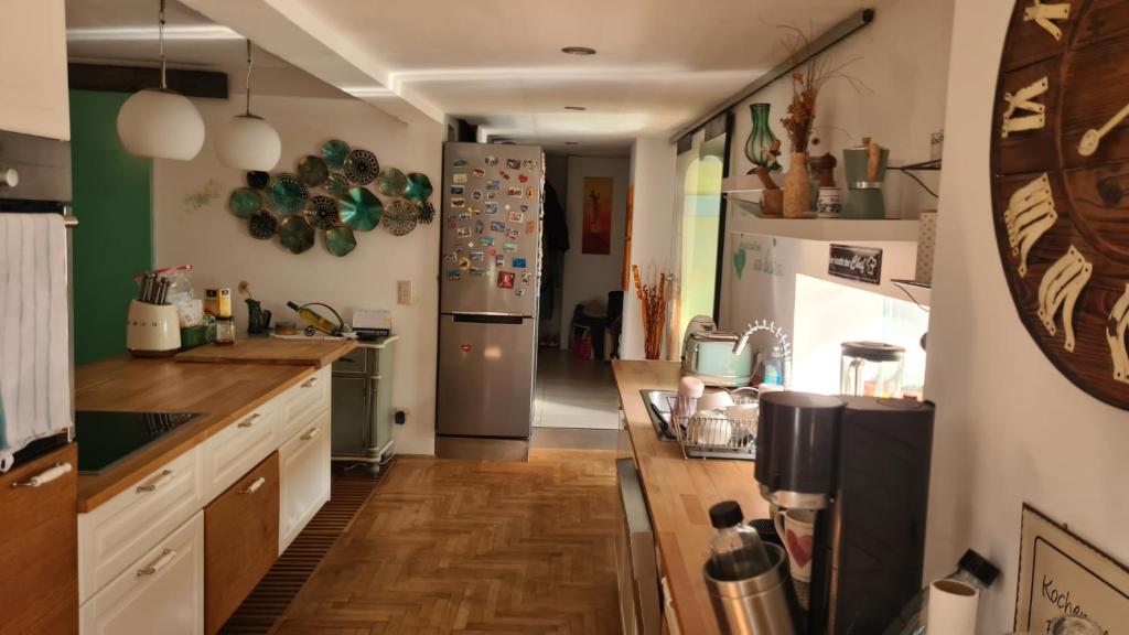 una cucina con frigorifero in acciaio inossidabile e pavimenti in legno di Spacious 4-Bedroom LOFT a Katzbach