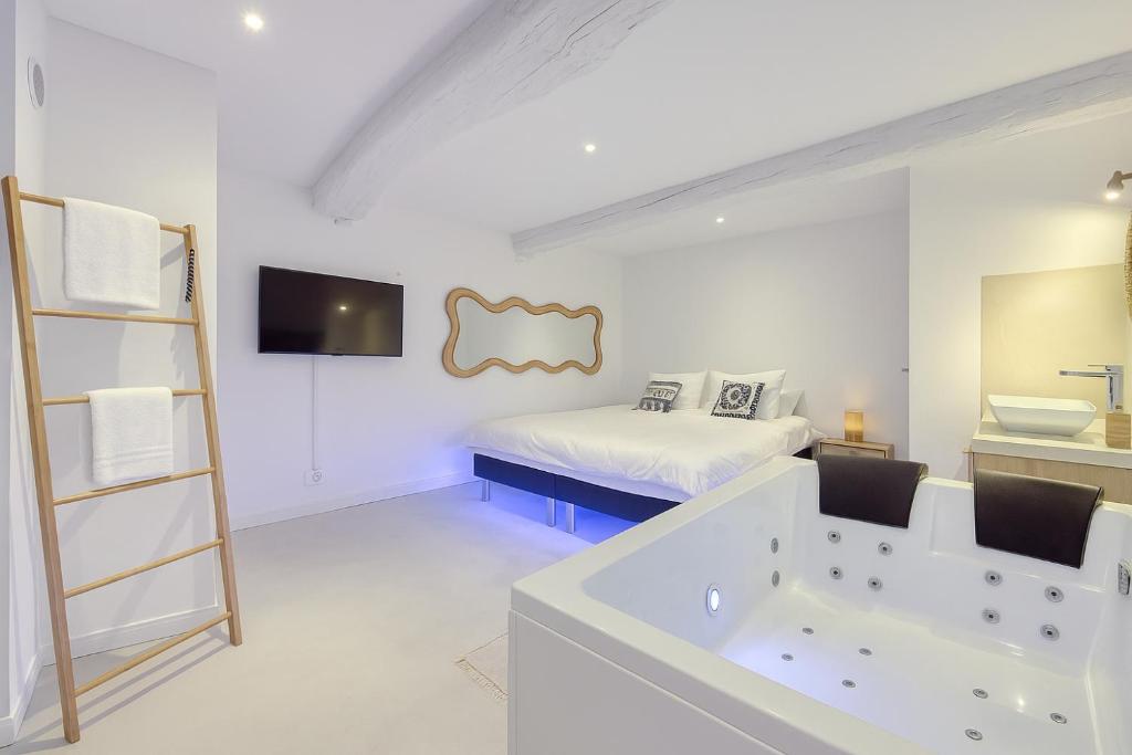 baño blanco con bañera y cama en Eros Suite, Greek-style apartment with Jacuzzi, en Brignoles