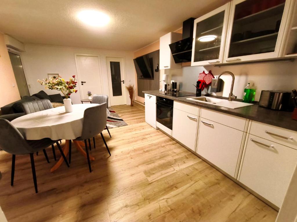 a kitchen and living room with a table and a kitchen and a dining room at Bungalow Am Schlosswald-Infrarotsauna, Klimaanlage&Terrasse - Wernigerode Harz in Wernigerode