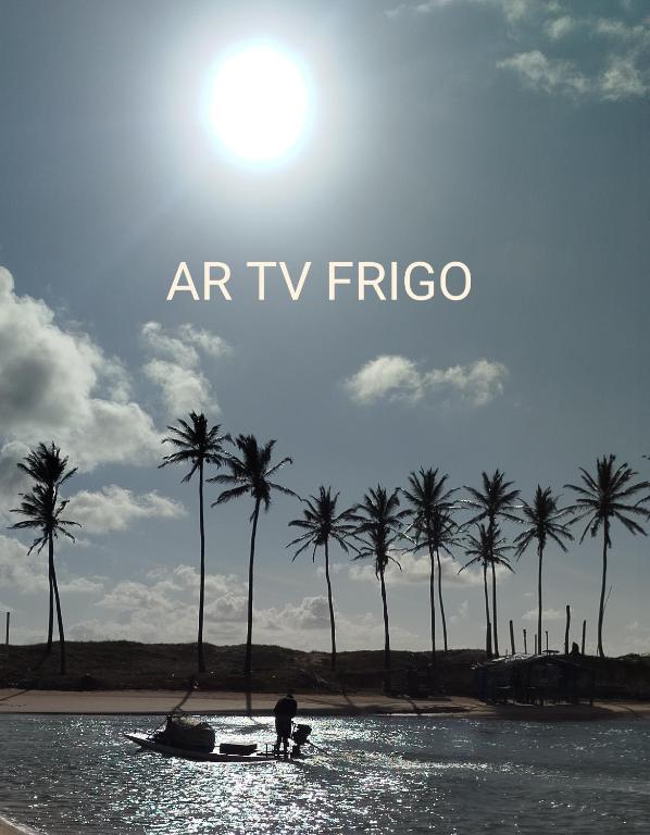 a man on a boat in the water with palm trees at Pousada Rio Mar in Maxaranguape