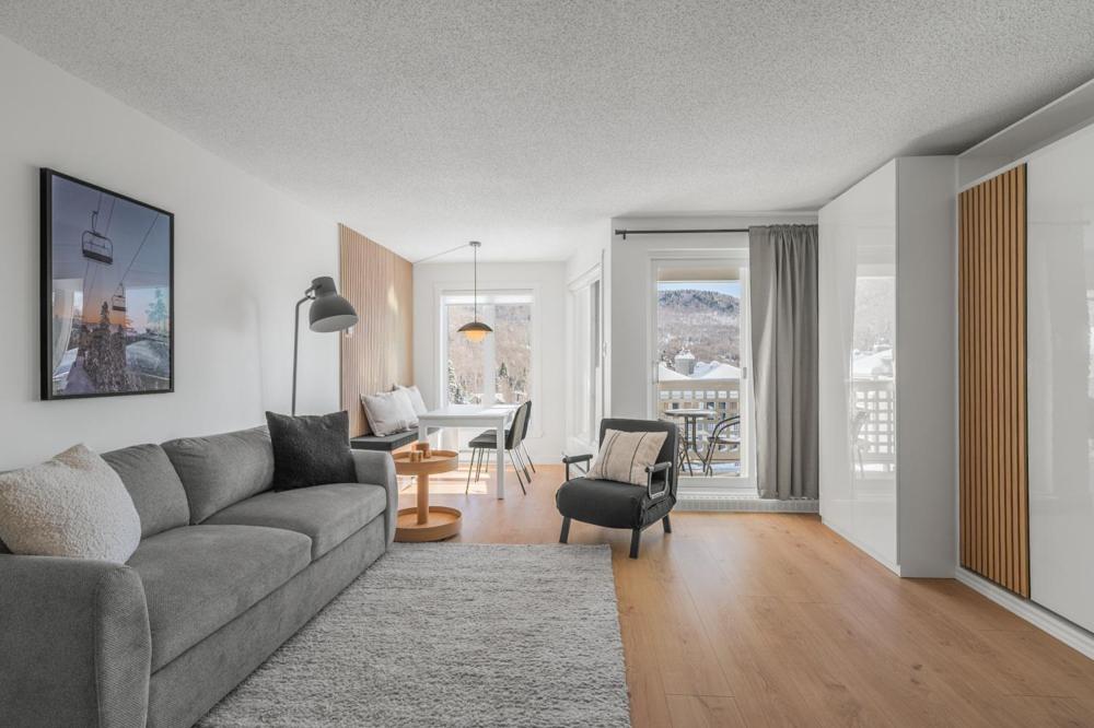 a living room with a couch and a table at Hameau 26-43 Studio in Stoneham