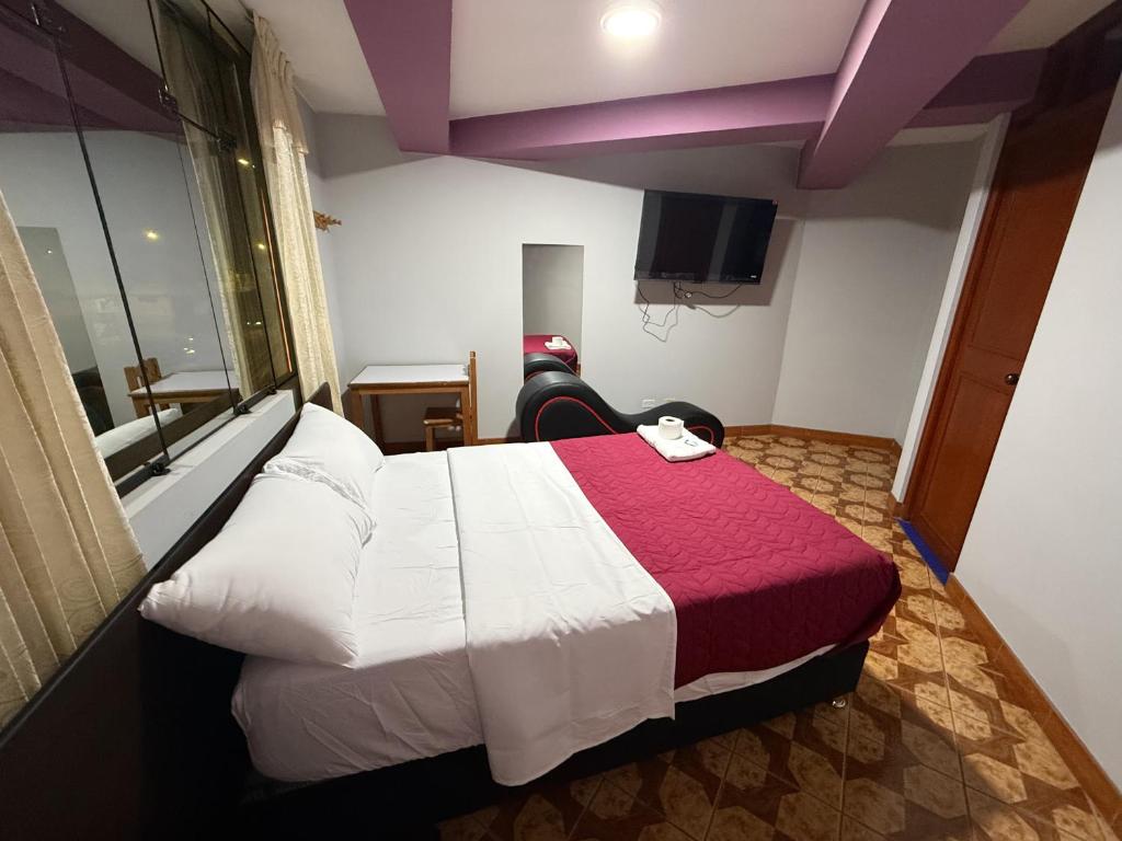 タクナにあるHostal Williamsのベッドとテレビがあるホテルの部屋