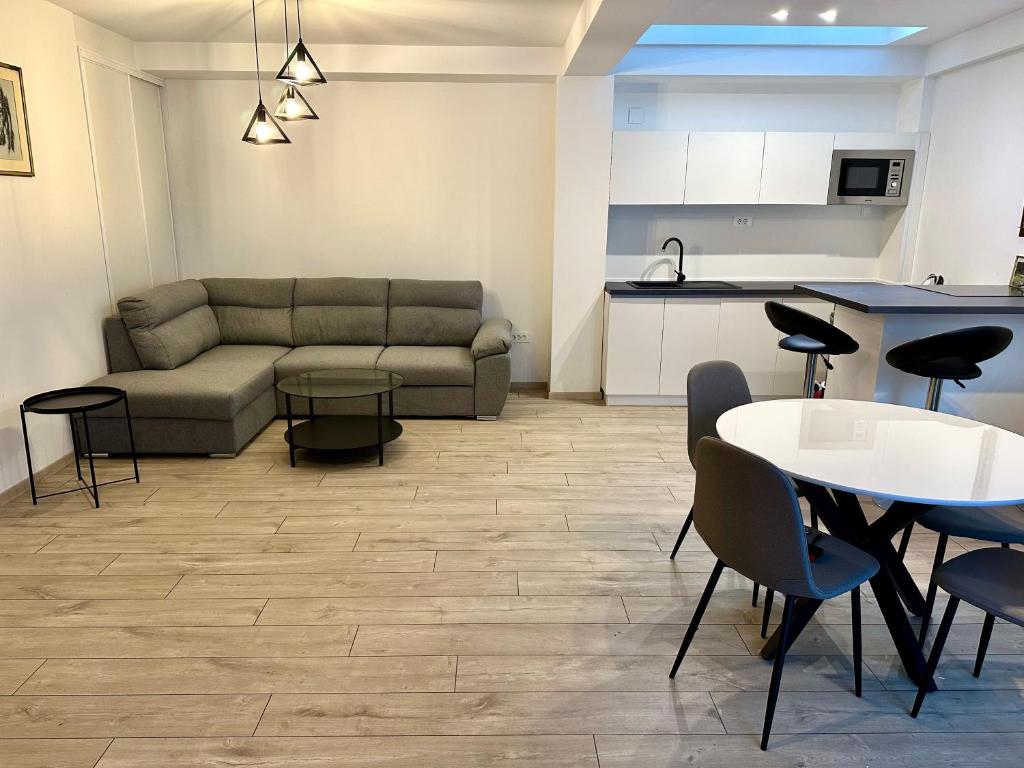 een woonkamer met een bank, een tafel en stoelen bij Vodno Apartment - Top location and private parking in Skopje