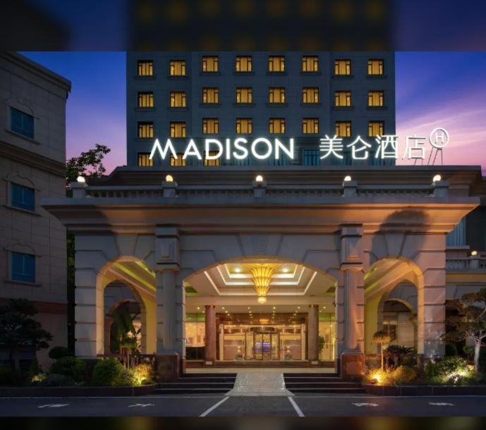 a large hotel with a sign on the front of it at Madison Hotel Shanghai Gongkang in Shanghai