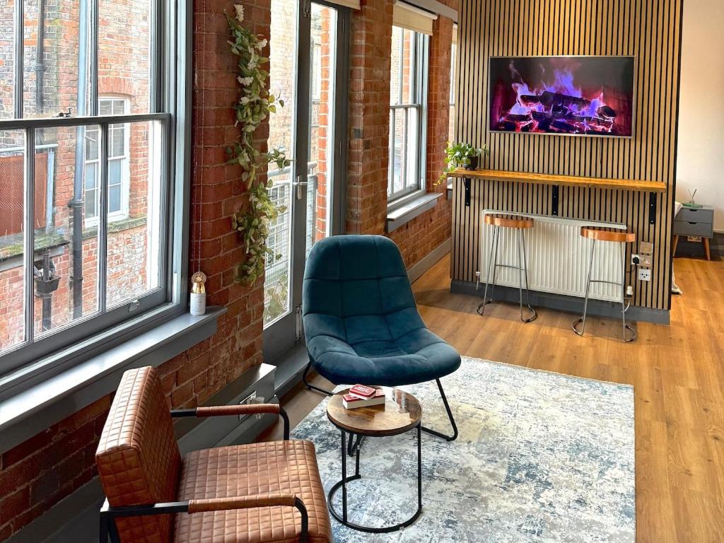 a living room with a blue chair and a table at Stylish City Loft Getaway in Nottingham