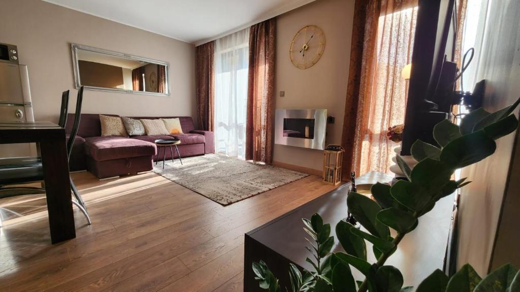 een woonkamer met een bank en een tafel bij SPOMAR One Bedroom Apartment in Bansko