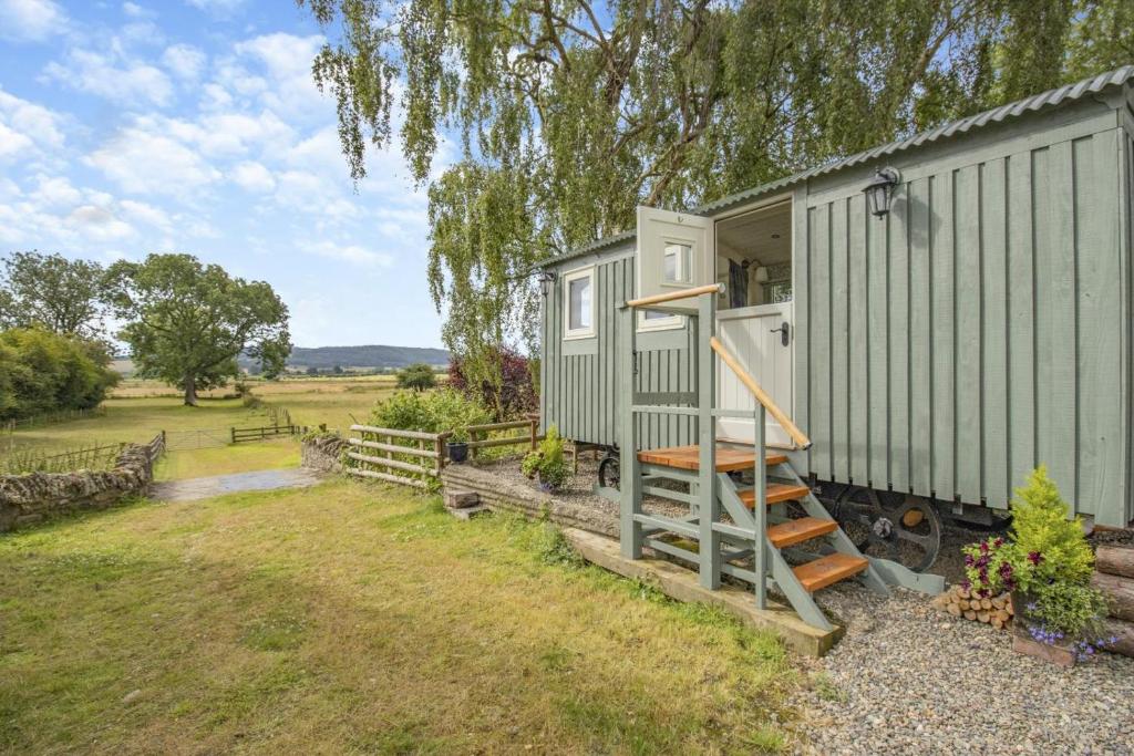 a green tiny house with a staircase next to it at 1 Bed in Leintwardine oc-b29785 in Brampton Bryan
