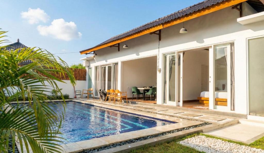 eine Villa mit einem Swimmingpool vor einem Haus in der Unterkunft Mimi Rae Villa Canggu in Dalung