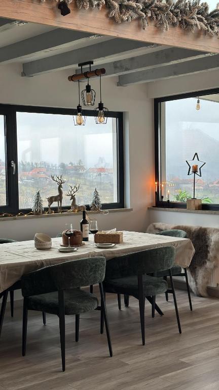 a dining room with a large table and some windows at SweetNest in Gurahonţ