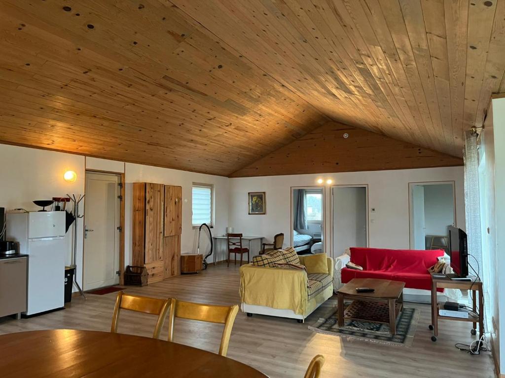 una sala de estar con un sofá y una mesa en Le Saint-Germain - Maison en bois en pleine nature, en Saint-Germain-Chassenay