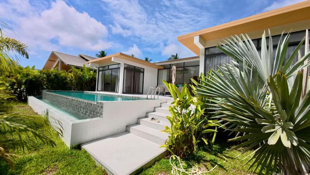 een villa met een zwembad en een huis bij White Lotus Villa in Ban Madua Wan