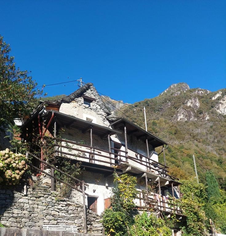 an old building on a hill with a mountain at Casa Mönä in Corippo
