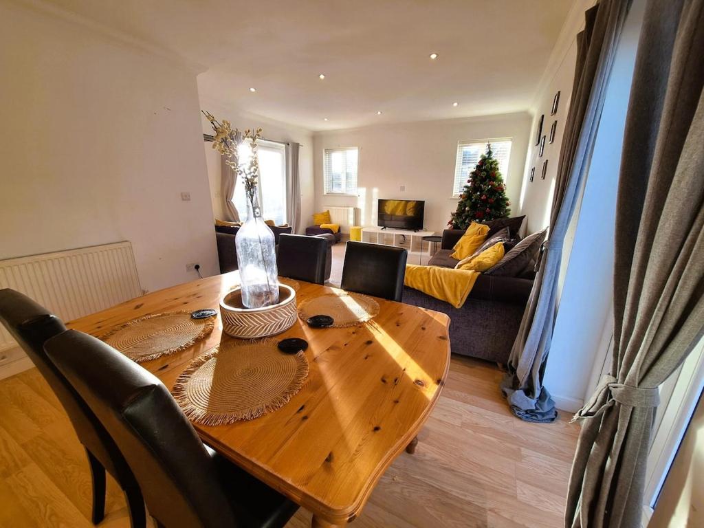 a living room with a wooden table and a couch at Modern home close to amenities and transport links in Wymondham