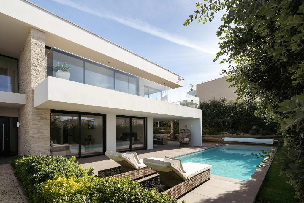 a house with a swimming pool in front of it at Ocean & Pool Retreat Villa by HostWise in Amoreira