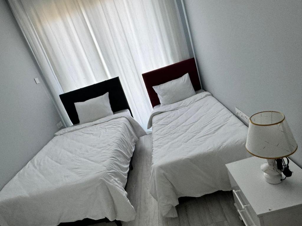 twee bedden in een slaapkamer met een lamp en een tafel bij Two Bedroom Kyrenia in Kyrenia