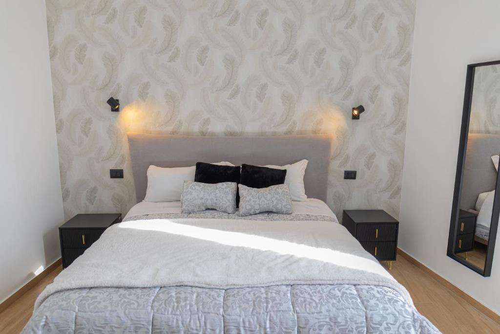 een slaapkamer met een groot bed met twee nachtkastjes bij LIONS ROOMS Augusta in Augusta