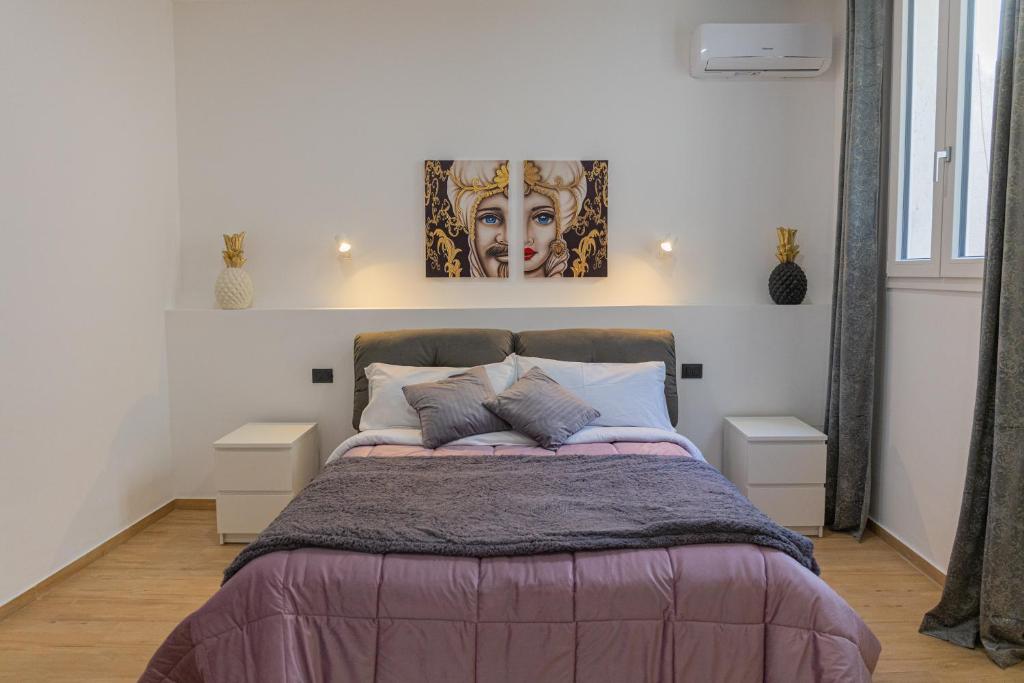 a bedroom with a bed with a painting on the wall at LIONS ROOMS Augusta in Augusta