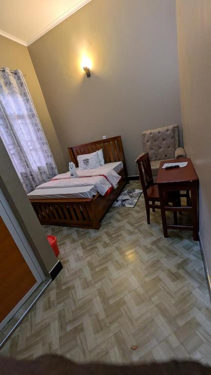 UyoleBeita Executive Lodge的一间卧室，里面有一张床、一张桌子和一把椅子