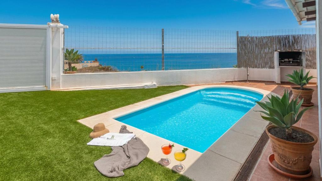 ein Swimmingpool in einem Hof mit Blick auf das Meer in der Unterkunft Villa Paraiso Torrox by Ruralidays in Torrox