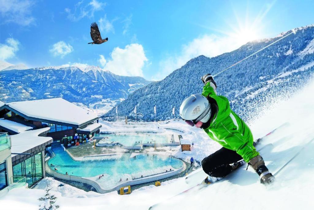 Una persona con esquís en la nieve junto a una estación de esquí. en Centre Thermal 2 chambres studio EV210, en Arni Alp