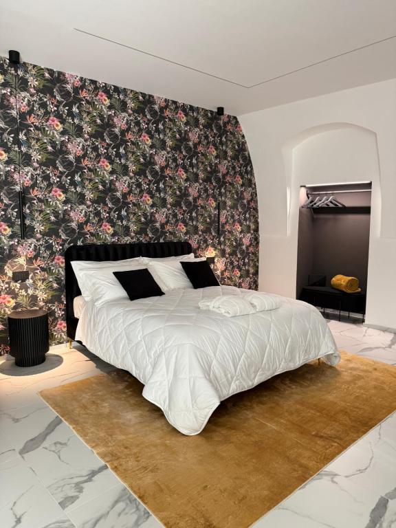 Ein Schlafzimmer mit einem großen Bett und einer floralen Tapete. in der Unterkunft Kari Suite in Sammichele di Bari