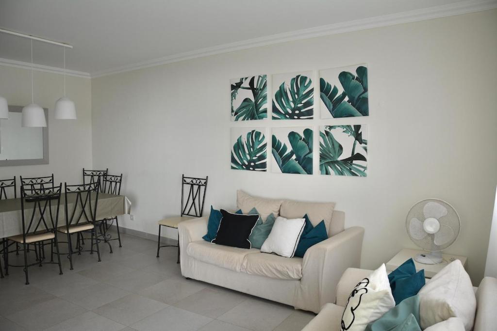 Una sala de estar con un sofá y un comedor. en Apartamento Miramar, en Armação de Pêra