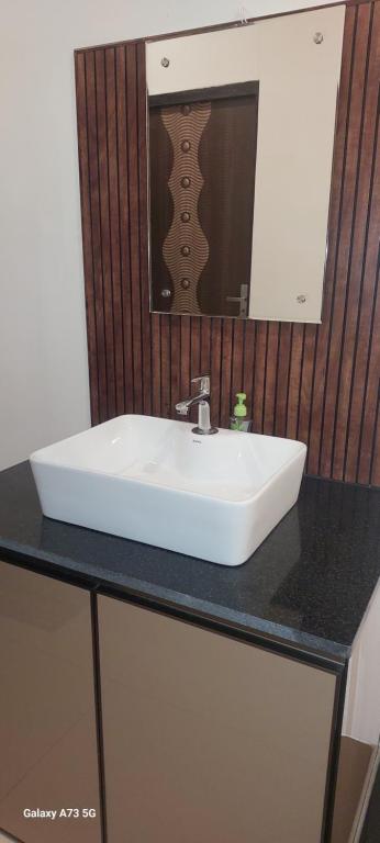 ein weißes Waschbecken auf einer schwarzen Ablage in einem Badezimmer in der Unterkunft Hill valley farm resort in Viripara