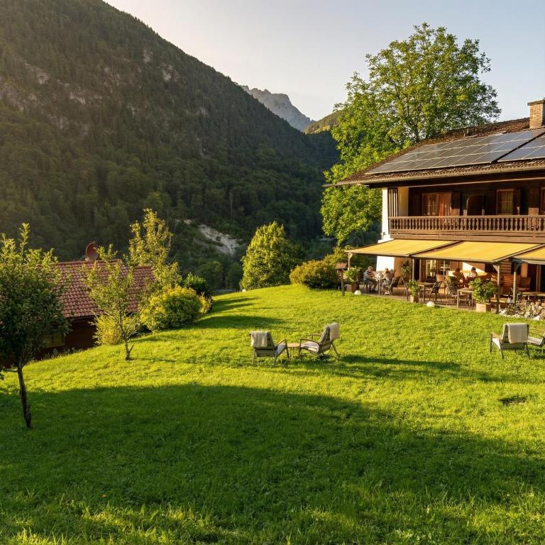 a large yard with chairs and a house at Hotel & Chalets Lampllehen in Marktschellenberg