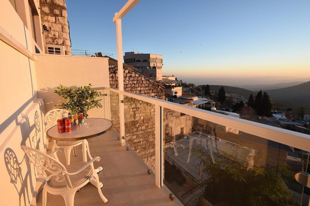 Un patio con una mesa y sillas en un balcón. en Moses Luxury apartments -nobility, en Safed