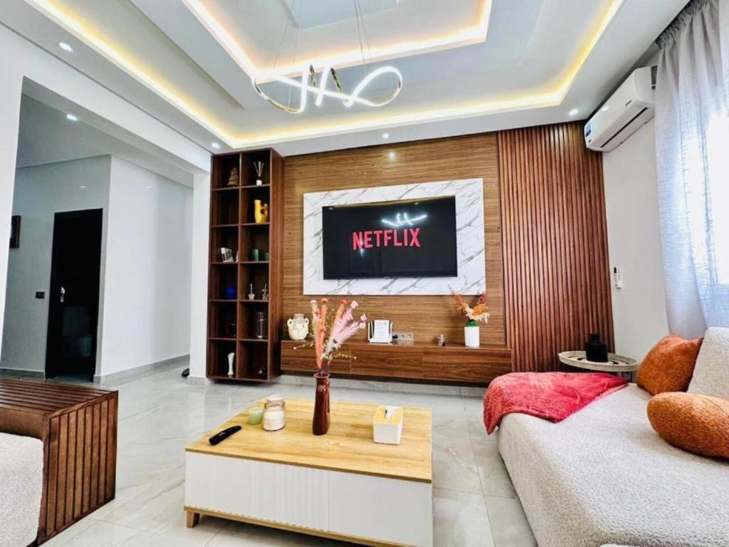 Una sala de estar con un televisor en la pared. en Elegant 3BR Stay 5min to Hay Riad, en Temara