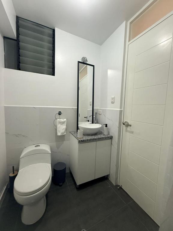 une salle de bains blanche avec toilettes et lavabo dans l'établissement SB5 Apartment, à Cusco