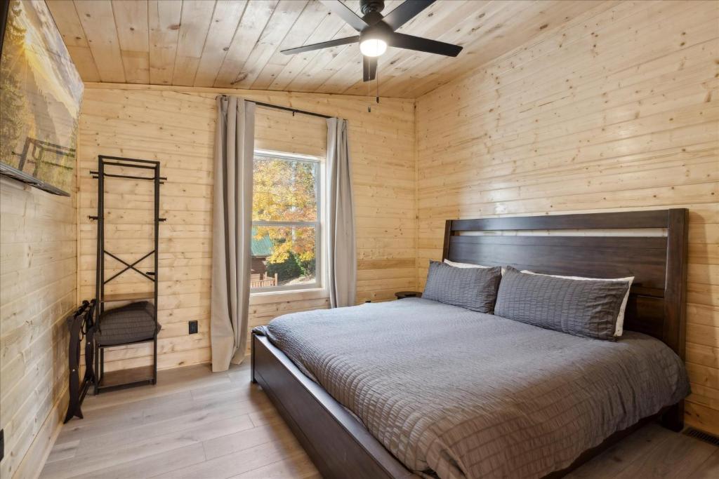 a bedroom with a bed and a ceiling fan at Green & Black Bear Cabins By Beyond Expectations in Sevierville