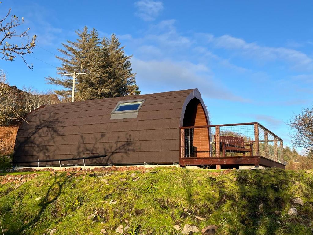 un piccolo edificio con un ponte in cima a una collina di Inverpod a Lochinver