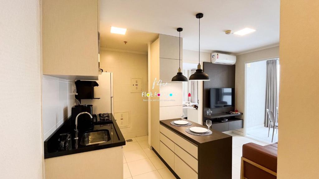 uma pequena cozinha com pia e geladeira em #2207A# Flat mobiliado no Jardim Goias em Goiânia