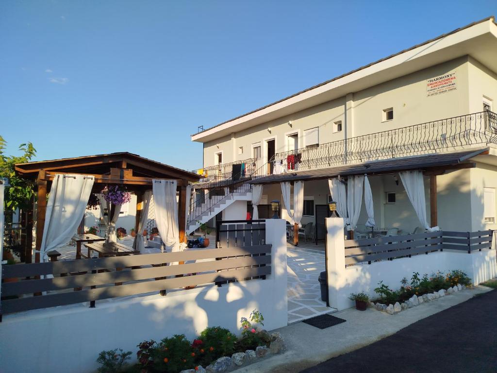 a building with a balcony with people sitting at tables at Harmony Apartments in Larisa